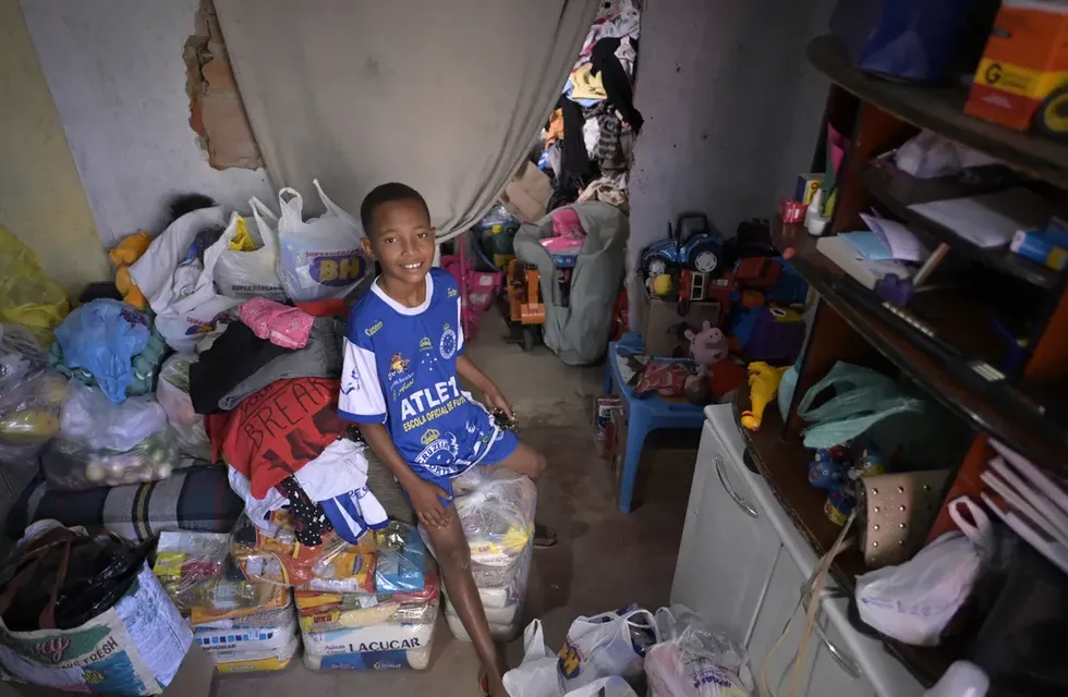 Miguel Barros, el niño de 11 años que recibió donaciones de alimentos después de llamar a la policía porque tenía hambre, mira su casa en Santa Luzia, un municipio de Belo Horizonte, Brasil. Foto: AFP
