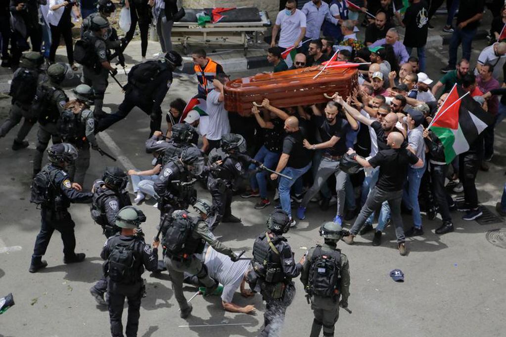Los agentes israelíes se enfrentan a los asistentes al funeral de Shireen Abu Akleh a la salida del hospital, en Jerusalén. / Foto: AP