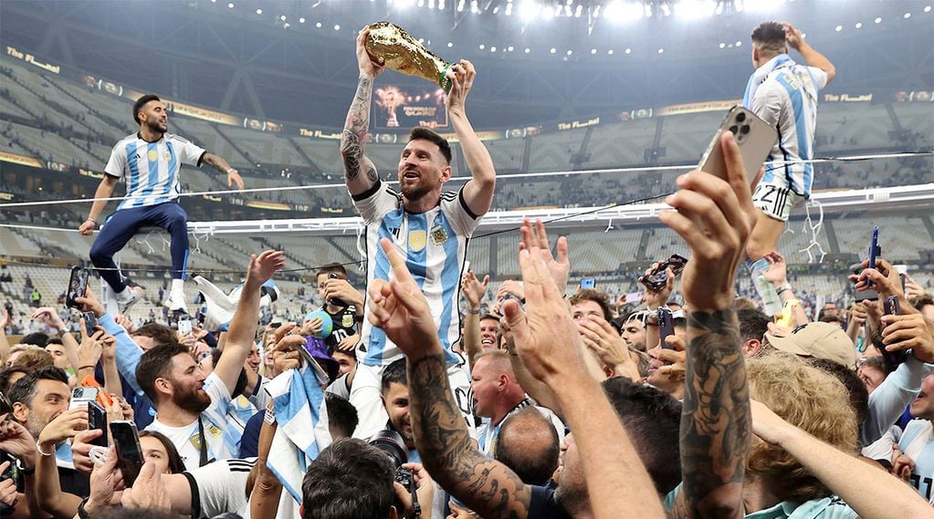 Lusail (Qatar), 18/12/2022.- Lionel Messi of Argentina (C) lifts the trophy as he celebrates with teammates and fans winning the FIFA World Cup 2022 Final between Argentina and France at Lusail stadium, Lusail, Qatar, 18 December 2022. (Mundial de Fútbol, Francia, Estados Unidos, Catar) EFE/EPA/Tolga Bozoglu

