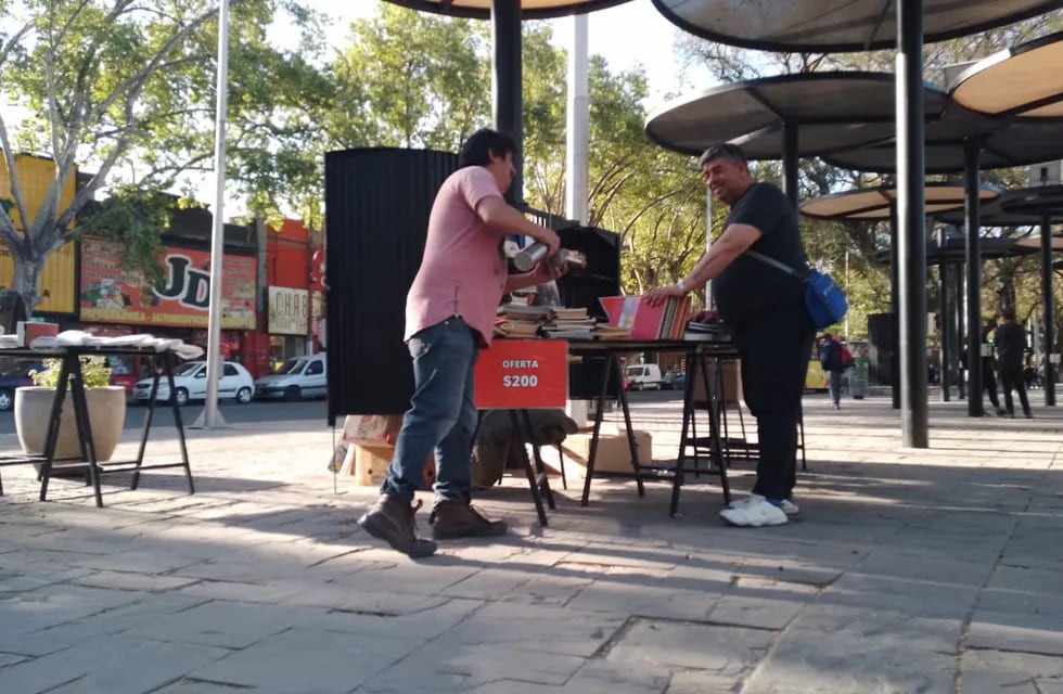 El vendedor de libros Roberto Mignani, junto a un colega en el espacio del Paseo Alameda de avenida San Martín y Córdoba.