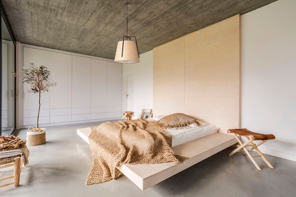 Light bedroom with wooden ceiling and large bed