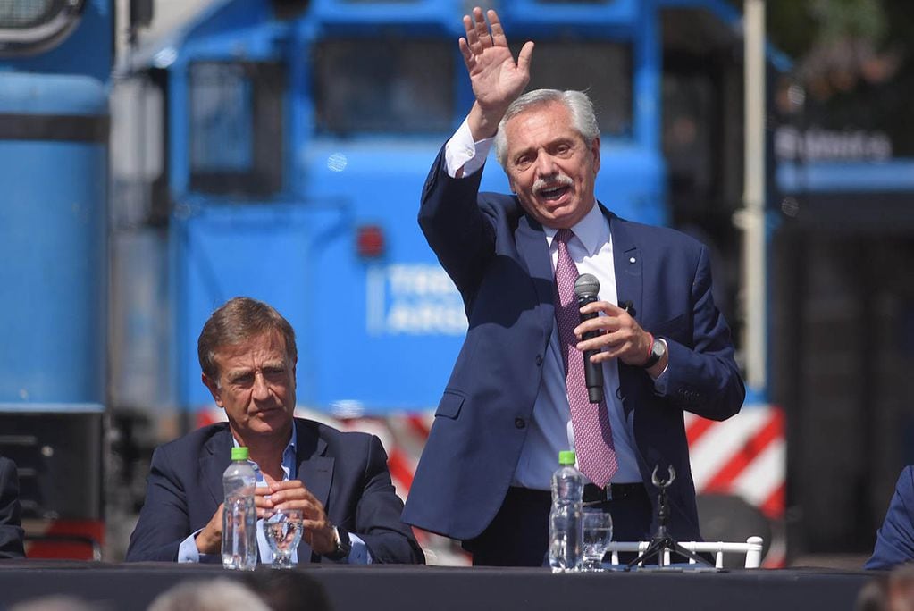 El presidente Alberto Fernández hablando de las ventajas de su gobierno y de las del tren que nunca funcionó. El gobernador Suárez escucha incrédulo.