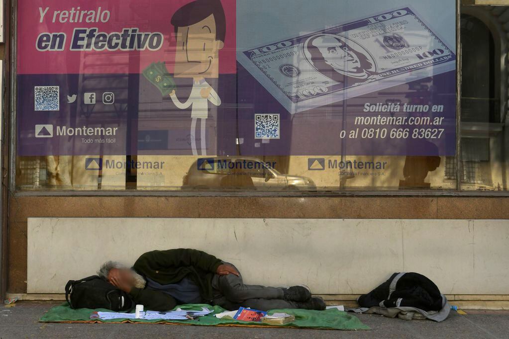 Una persona sin hogar duerme en una desierta vereda del centro mendocino.