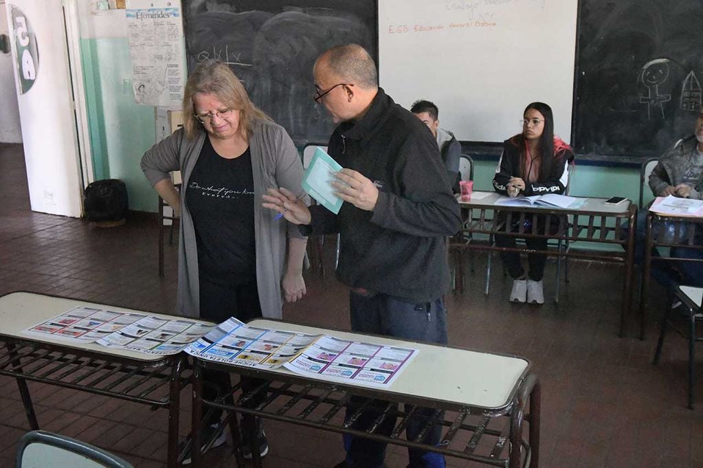 Elecciones PASO en 7 departamentos de la provincia de Mendoza. El Presidente de mesa, explica a una votante el sistema de realizar el voto
Foto: José Gutierrez / Los Andes 