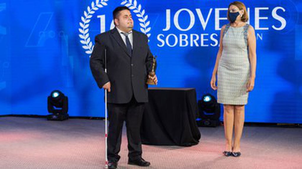 De traje y corbata, Nicolás Martínez recibe galardón por ser uno de los 10 jóvenes sobresalientes de Argentina.
