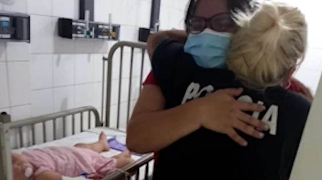 El emotivo abrazo entre la madre de la pequeña y la policía que salvó la vida de la beba.