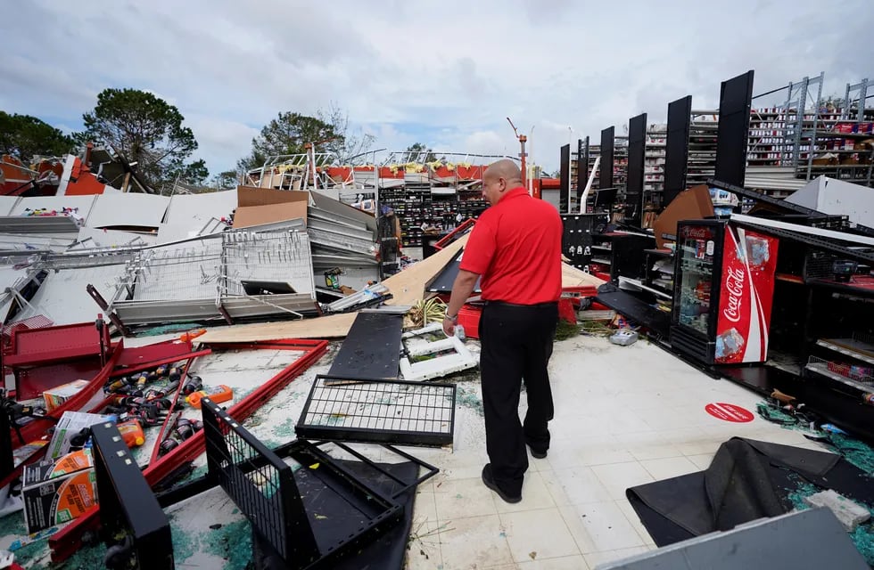 Un empleado de una tienda de autopartes inspecciona los daños a las instalaciones. Foto: AP.
