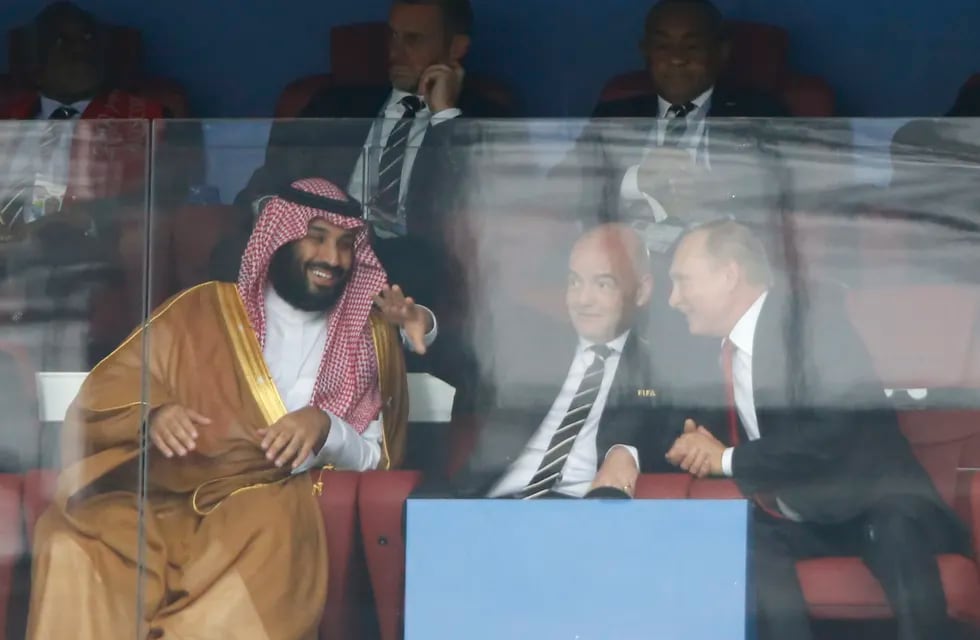 ARCHIVO - El príncipe heredero de Arabia Saudí Mohammed bin Salman (izquierda), el presidente de la FIFA Gianni Infantino (centro) y el presidente de Rusia Vladimir Putin conversa durante el partido inaugural entre Rusia y Arabia Saudí en la Copa Mundial de 2018, en el estadio de Luzhniki, en Moscú, el 14 de junio de 2018. (AP Foto/Hassan Ammar)