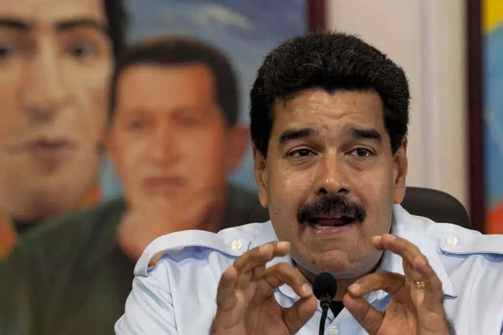 Batalla. Nicolás Maduro mostró ayer el decreto en que fija precios máximos para el alquiler de locales comerciales (AP).