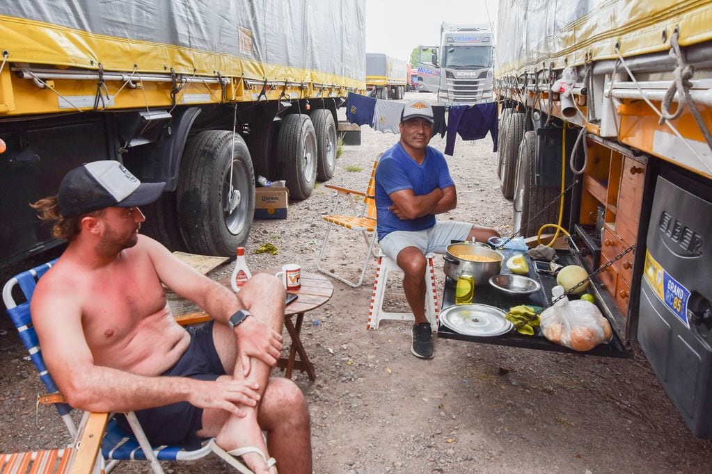 Ya hay casi 3.000 camiones varados y queda poco lugar en Mendoza: recomiendan no enviar carga a Chile. en la foto: un grupo de camioneros tucumanos comparten el almuerzo mientras realizan labores de higiene. 
(Mariana Villa / Los Andes)