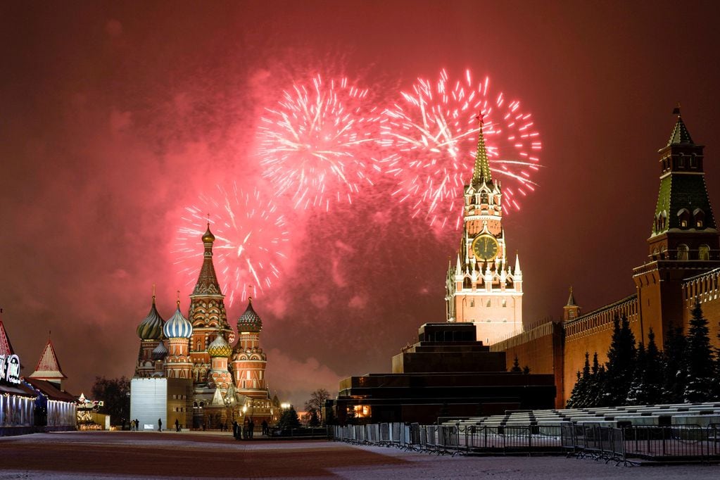 Fuegos artificiales explotan sobre la Catedral de San Basilio y el Kremlin con la Torre Spasskaya se ven en la Plaza Roja vacía debido a las restricciones pandémicas durante las celebraciones de Año Nuevo, en Moscú
