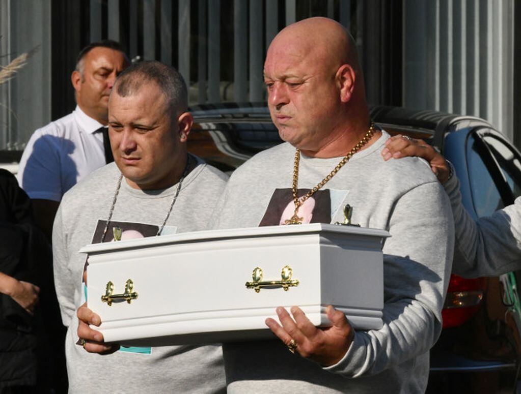 El padre de la víctima carga el pequeño ataúd hasta el cementerio.