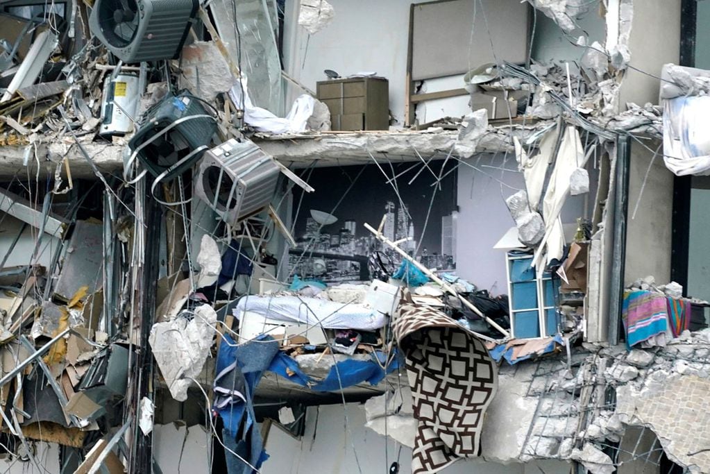 Artículos para el hogar y los escombros cuelgan del edificio colapsado. (AP) 