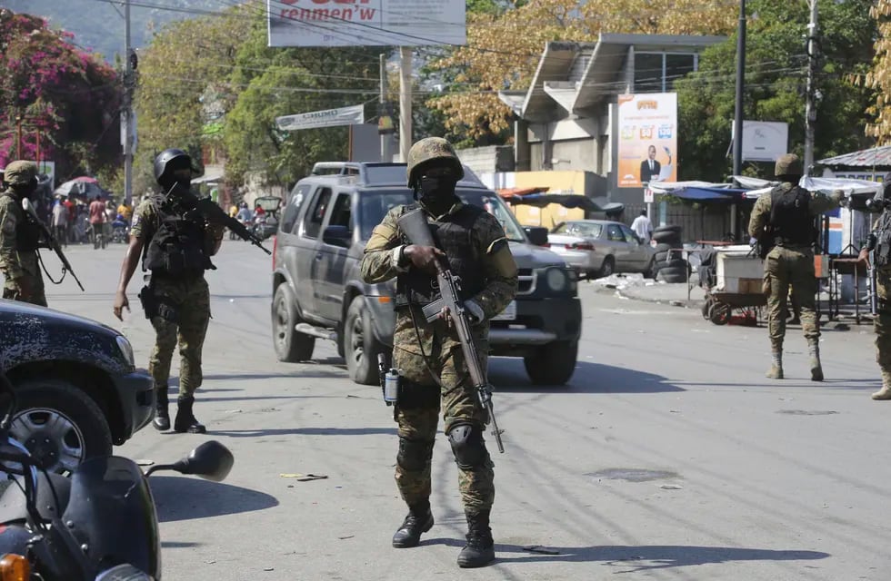 Elementos de la Unidad de Seguridad General del Palacio Nacional de Haití establece un perímetro para retomar el control de una de las tres delegaciones de policía que fueron tomadas por pandillas, en el centro de Puerto Príncipe, Haití, el sábado 9 de marzo de 2024. (AP Foto/Odelyn Joseph)