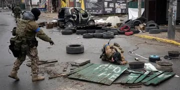 Soldados ucranianos retiran despacio escombros, buscando posibles minas abandonadas por el ejército ruso. (AP Photo / Vadim Ghirda)