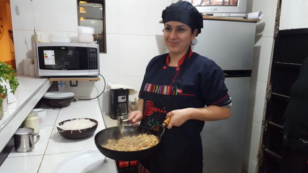 
    La nuera de doña Estela preparando el clásico arroz con mariscos peruano
   