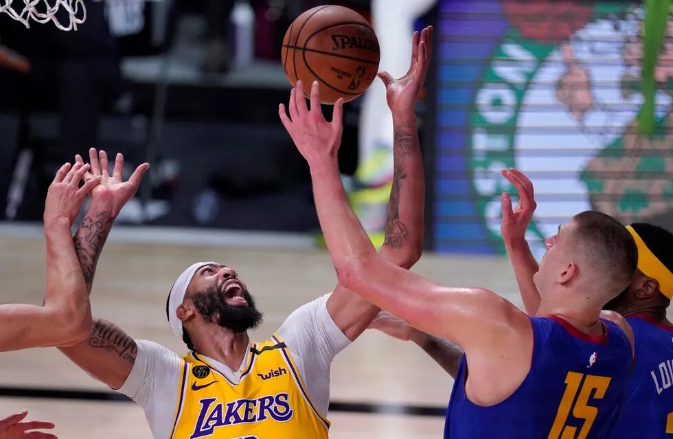 El jugador de Los Angeles Lakers Anthony Davis (izquierda) y su rival de Denver Nuggets, Nikola Jokic (15), compiten por el control del balón durante el segundo medio tiempo de la final de Conferencia Oeste de la NBA.