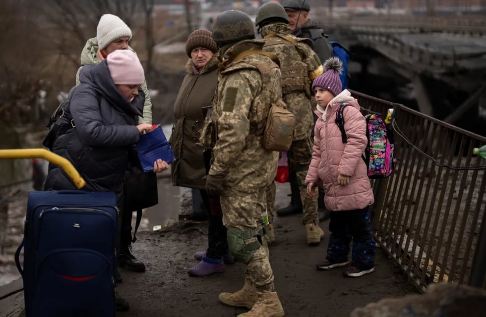 Soldados ucranianos revisan los documentos de identidad de las personas mientras huyen de sus vecindarios. (Foto / AP)