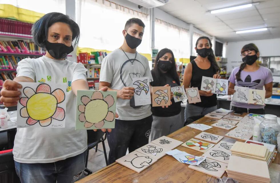 La artista Luisa Olguín junto a quienes la ayudan a montar el futuro mural en Luján, con dibujos de los chicos / Mariana Villa