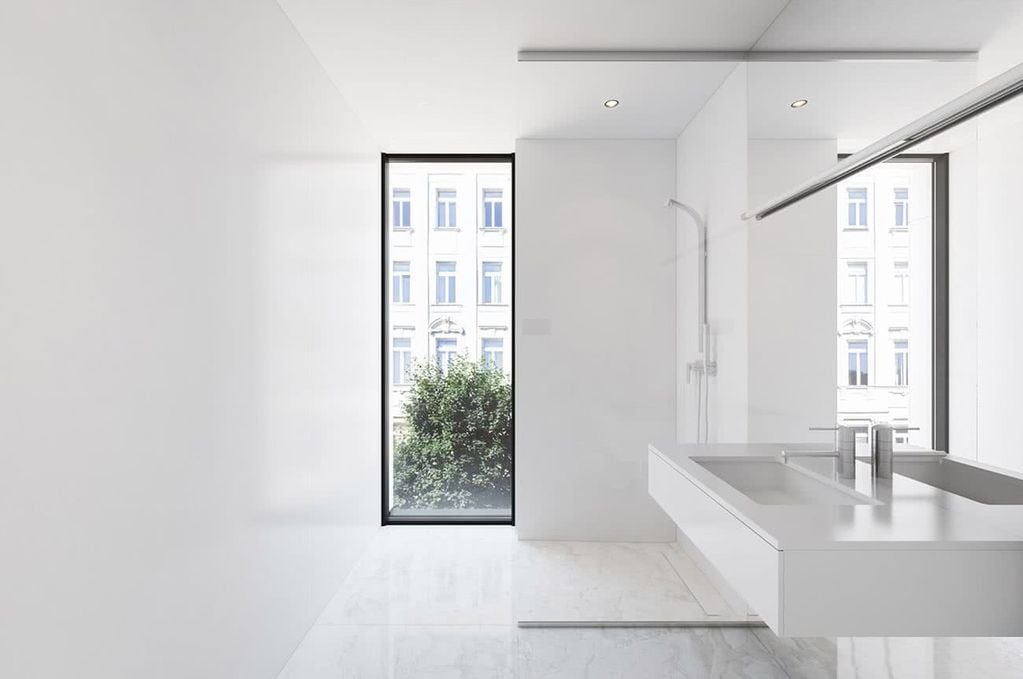 Baño minimalista, que recurre a los planos geométricos y la monocromía.