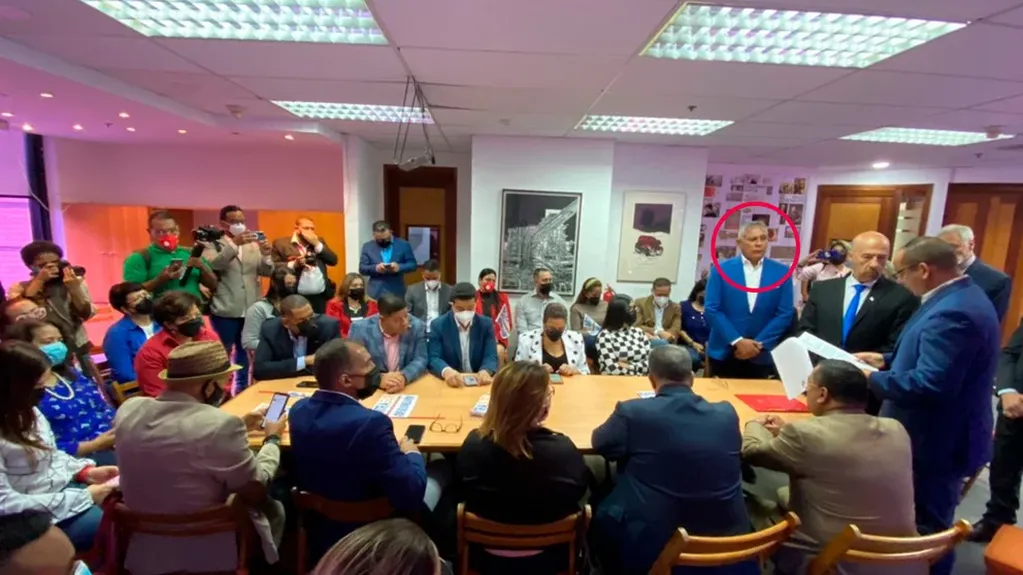 Pedro Carreño (círculo rojo), vestido de saco azul y camisa blanca, en la embajada argentina en Venezuela. Oscar Laborde, de corbata azul, dialoga con otro legislador. Foto: Web