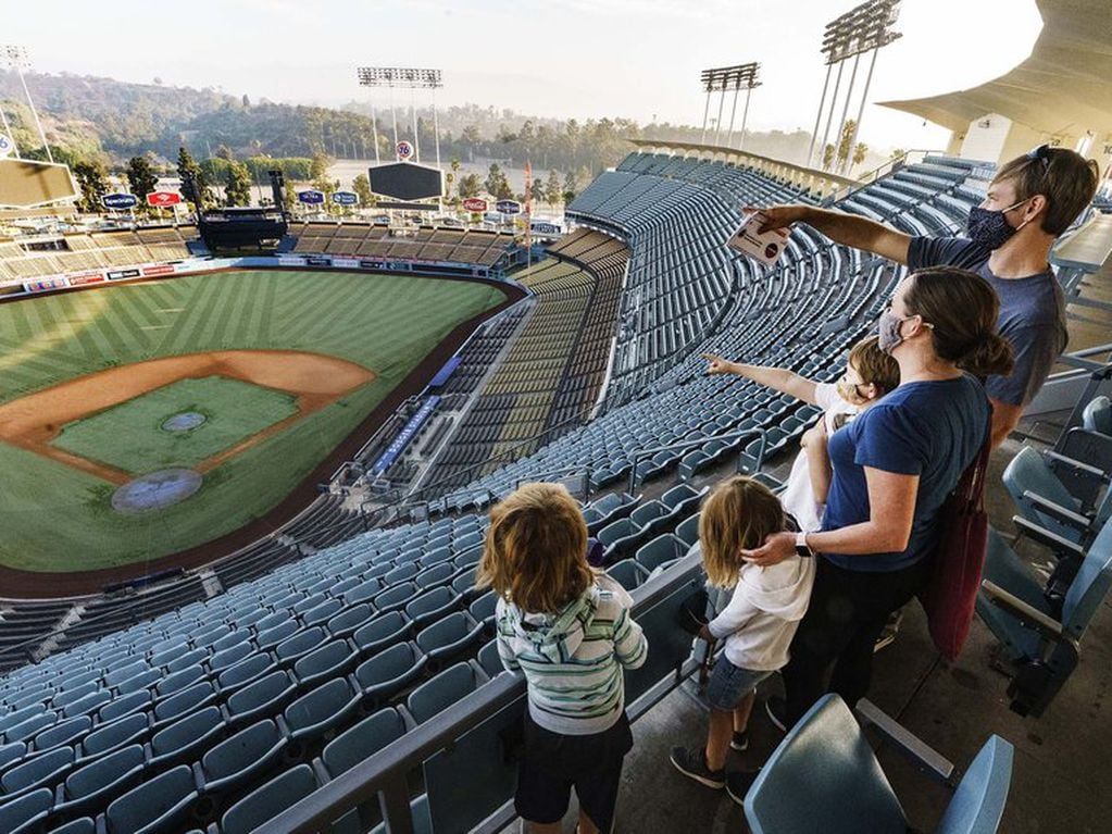 Brandon Malmberg y su esposa Debbie le explican las reglas del Beisbol a sus hijos, uego de votar en el estadio de los Dodgers, en Los Angeles (AP)