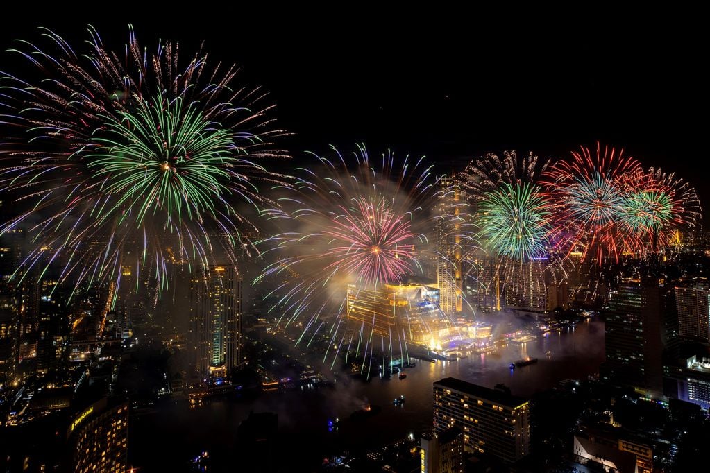 Los fuegos artificiales explotan sobre el río Chao Phraya durante las celebraciones de Año Nuevo en Bangkok, Tailandia.