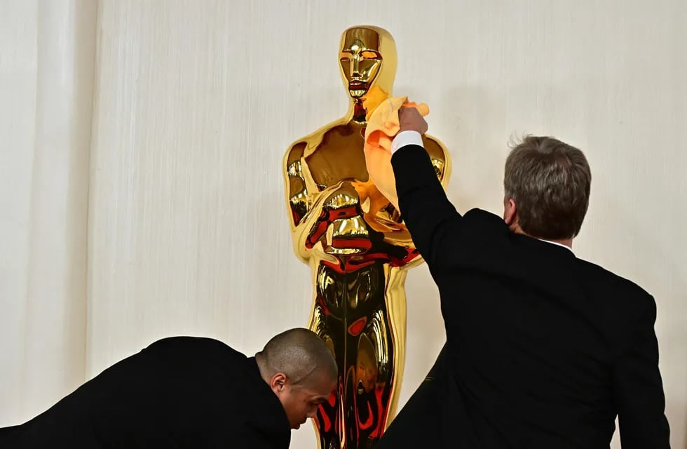 Personal del Dolby Theater limpia una réplica de la estatuilla de los Oscar que se entregan hoy, 10 de marzo.