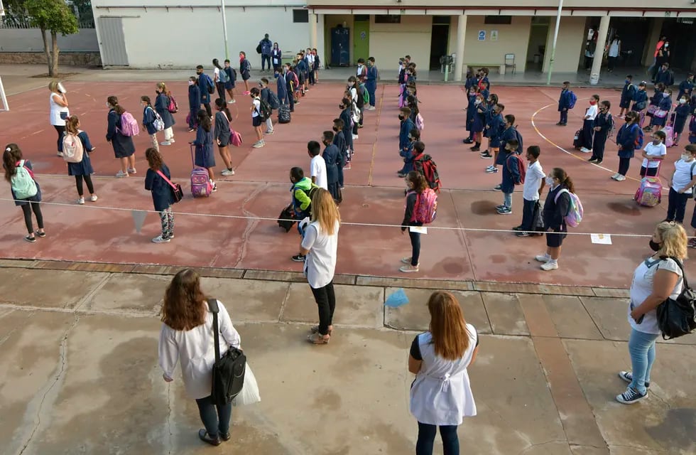 Alumnos y docentes ingresando con barbijo y distanciamiento: sin dudas, la imagen del año. Foto: Orlando Pelichotti / Los Andes