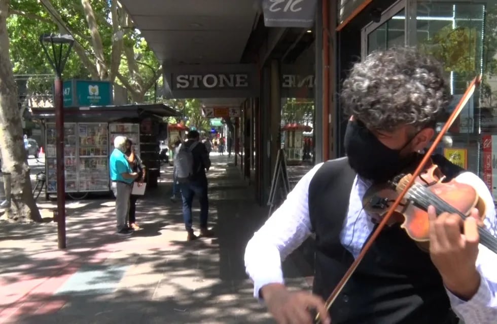 Vestido de manera muy elegante, Miguel Lucena toca su violín en la avenida San Martín.