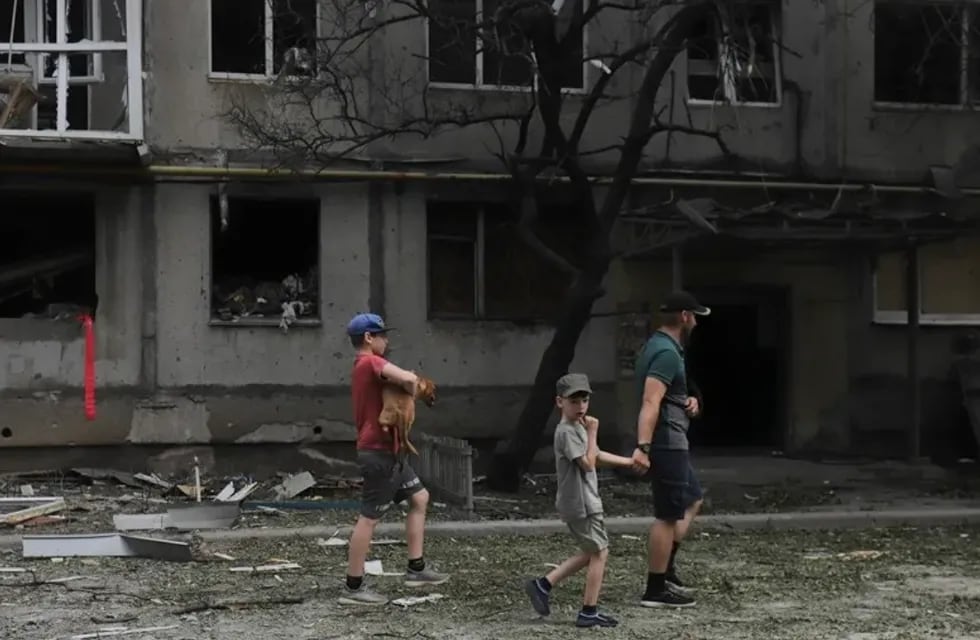Familia en una calle de la ciudad ucraniana de Bajmut, en la que se muestran los efectos de los bombardeos rusos. Foto: EFE/EPA