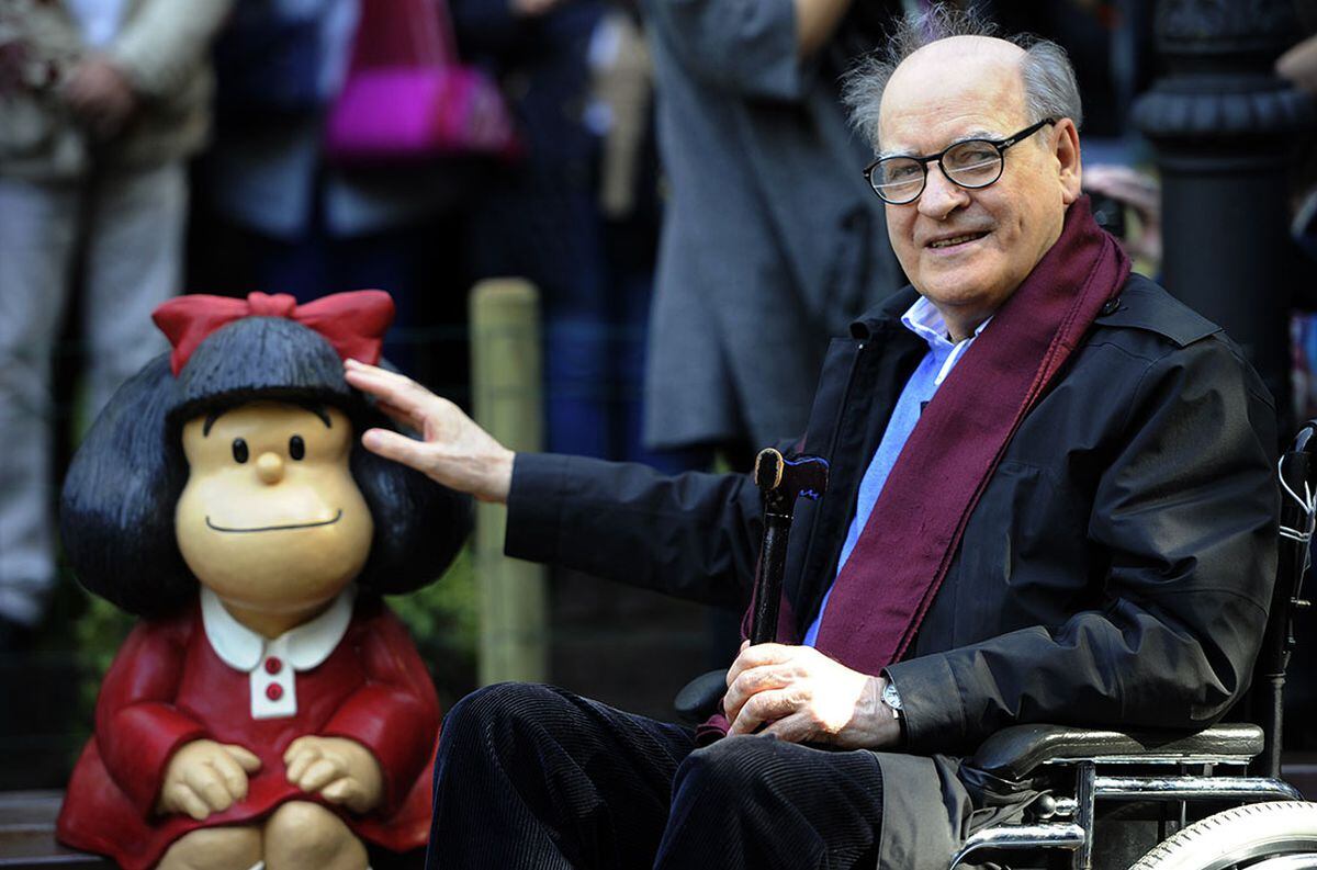 Quino posa junto a una escultura de Mafalda
