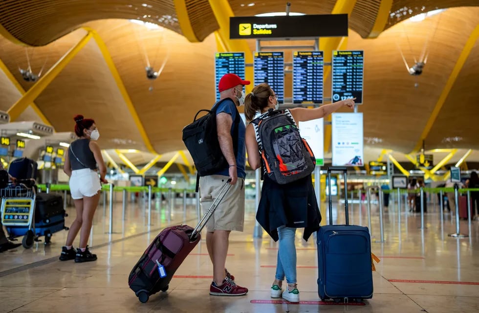 Los pasajeros revisan la pantalla de salida en el aeropuerto internacional Adolfo Suárez-Barajas en Madrid. Foto: AP
