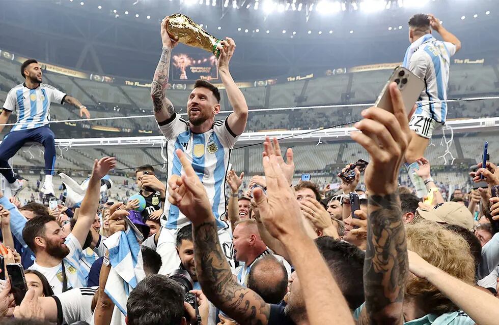 Lusail (Qatar), 18/12/2022.- Lionel Messi of Argentina (C) lifts the trophy as he celebrates with teammates and fans winning the FIFA World Cup 2022 Final between Argentina and France at Lusail stadium, Lusail, Qatar, 18 December 2022. (Mundial de Fútbol, Francia, Estados Unidos, Catar) EFE/EPA/Tolga Bozoglu