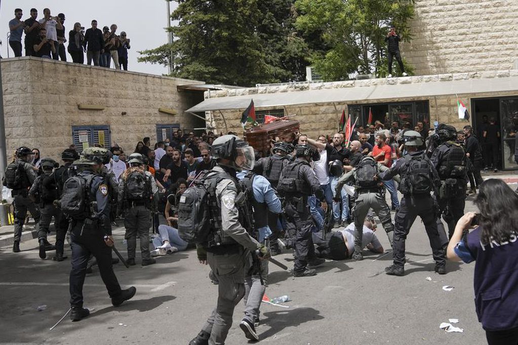 El féretro de la periodista, que iba cubierto por la bandera palestina, ha estado a punto de caer al suelo cuando los agentes han tratado de disolver a los congregados a la salida del hospital.
