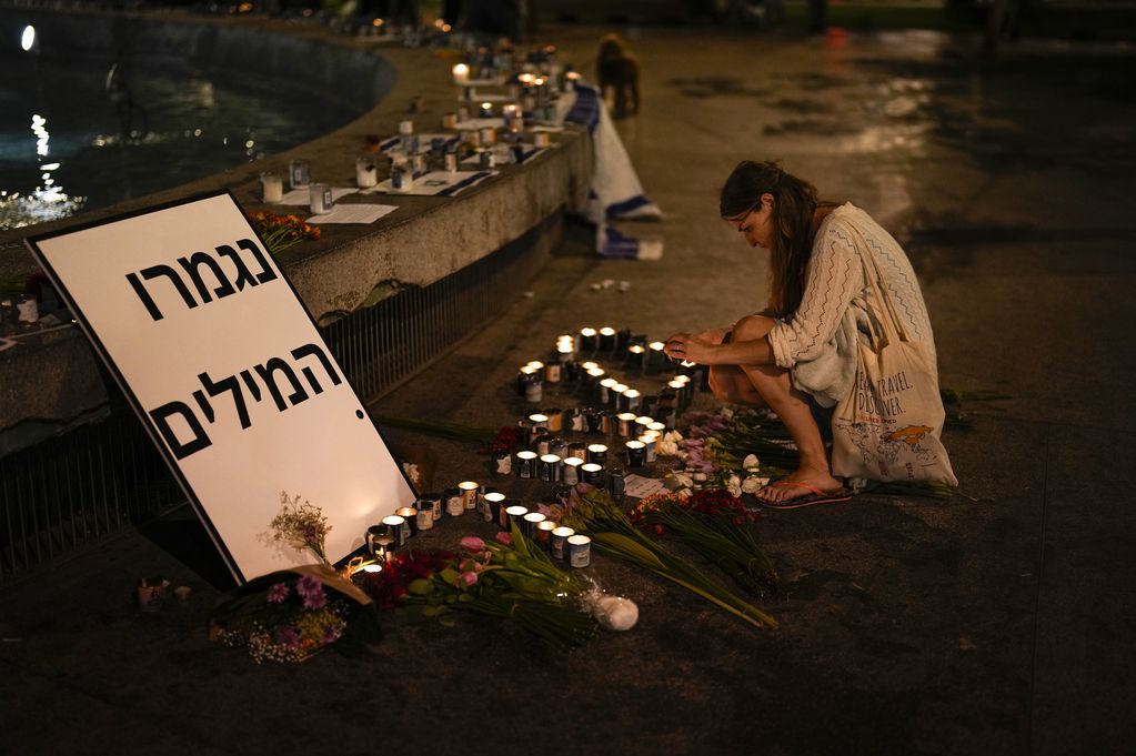 Una mujer enciende una vela en honor a las víctimas del ataque de Hamas durante una vigilia en Dizengoff en el centro de Tel Aviv, el viernes 13 de octubre del 2023. (AP Foto/Francisco Seco)