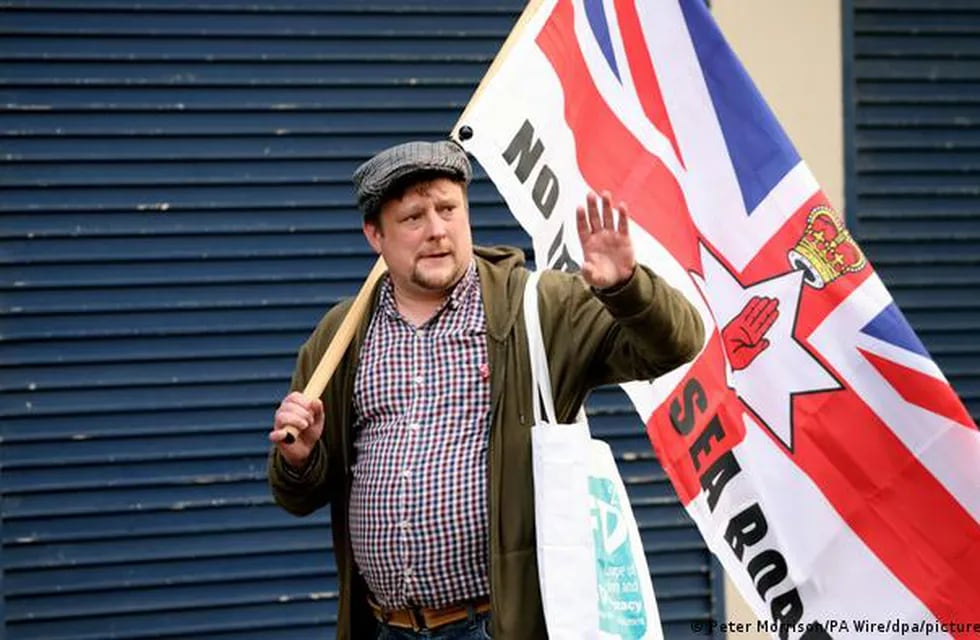 Irlanda del Norte. Un ciudadano protesta con la bandera de Reino Unido y la de Irlanda del Norte por los corredores marítimos comerciales. Imagen de archivo de junio de 2022.