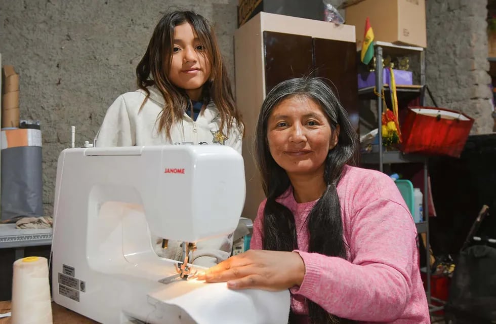 Katty de nacionalidad boliviana vive en el Algarrobal de abajo y trabaja junto a su marido y sus hijos en hornos de ladrillos, un trabajo muy pesado que la llevó a aprender costura y asi enseñarle a su hija para que tenga un trabajo mas liviano
Katty enseña a su hija Mailén  a trabajar con las máquinas de coser  
Foto: José Gutierrez / Los Andes 