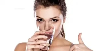 Mujer bebe agua (Ilustrativa)