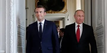 French President Emmanuel Macron walks with Russian President Vladimir Putin at the Chateau de Versailles as they meet for talks before the opening of an exhibition marking 300 years of diplomatic ties between the two countries in Versailles