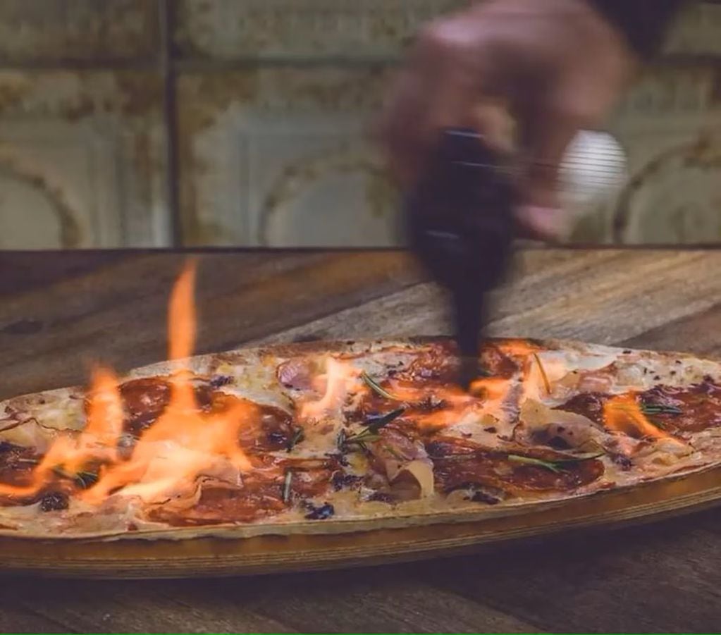 La pizza flambeada se enciende con un soplete. Foto: TN.