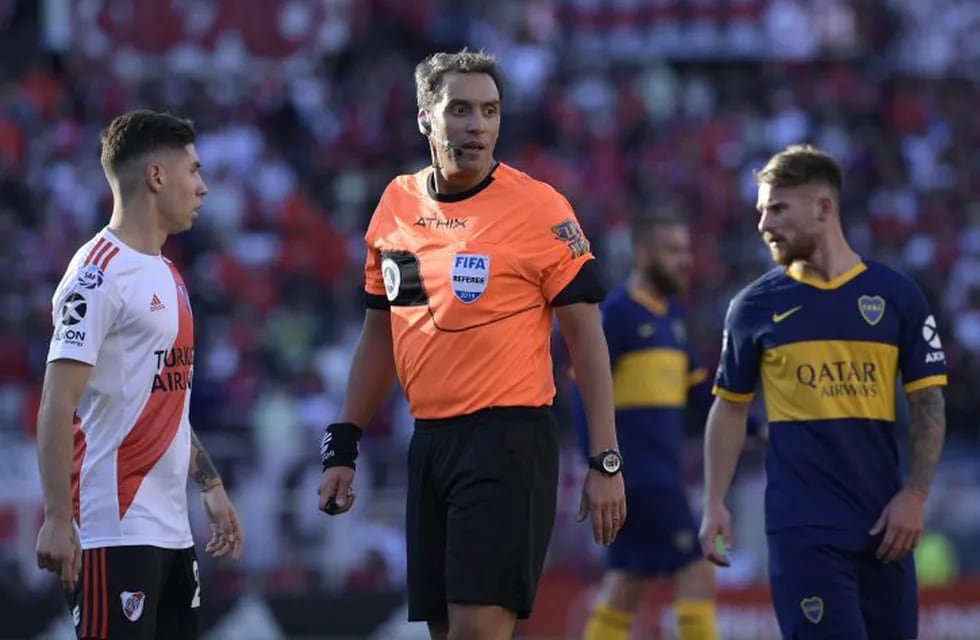 Referee Fernando Rapallini (C) gestures during the Argentine Superliga first division football match between River Plate and Boca Juniors at the \