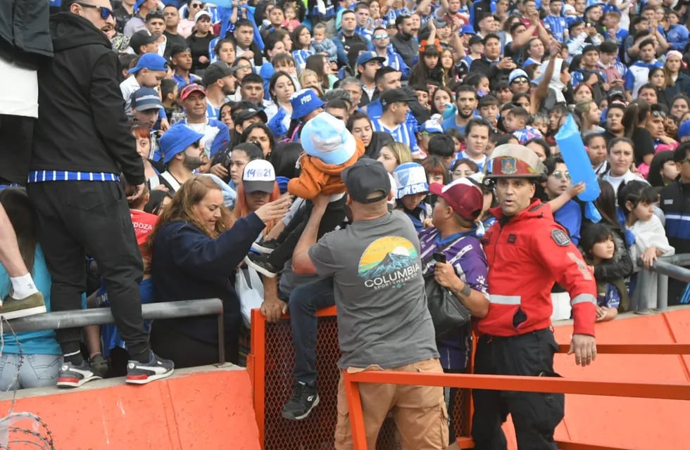 Los hinchas de Godoy Cruz le escapan al gas pimienta que tiró la pelicía en las afueras del estadio para dispersar a la barra / José Gutiérrez.