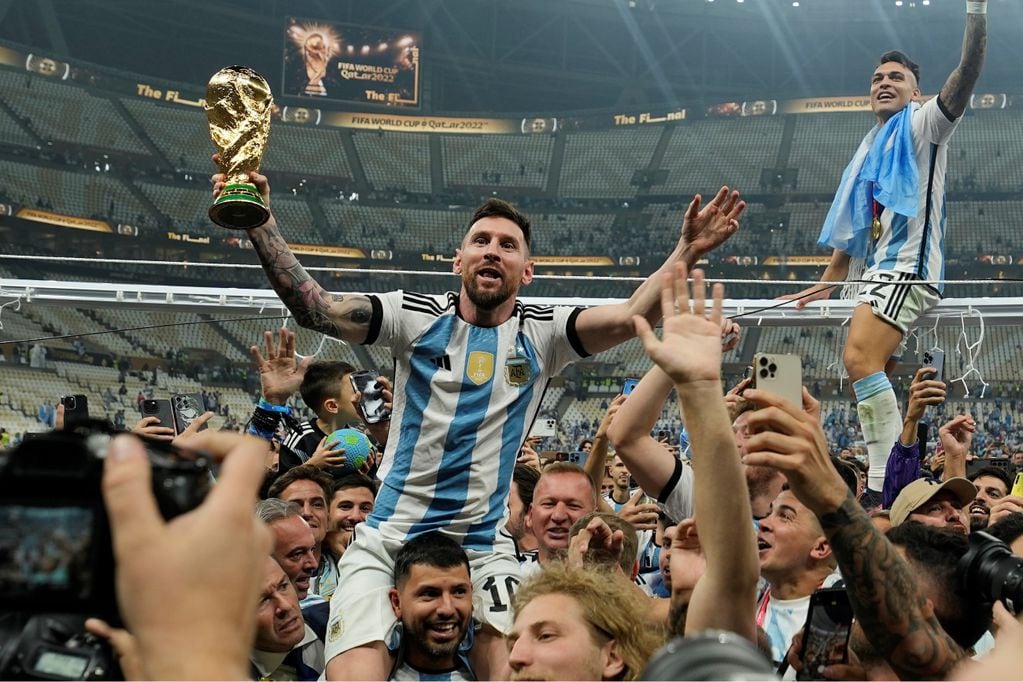 Agüero lleva en andas a Messi tras ganar el Mundial de Qatar. Los dos estarán presentes en el Monumental. (AP)