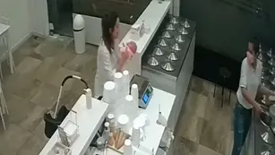 Mujer pesa a su bebé en la balanza de una heladería