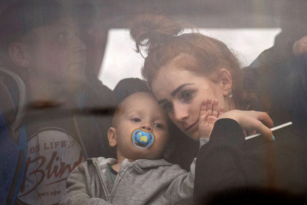 Una mujer sostiene a su bebé dentro de un autobús cuando salen de Kiev, Ucrania. 