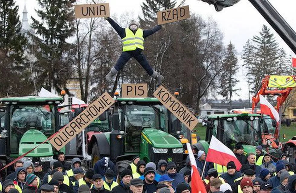 Agricultores polacos protestan en Czerniczyn, cerca de la frontera con Ucrania. En la pancarta se lee 'UE', 'Gobierno', abajo desde la izquierda: 'Oligarcas' y 'usurpador de la justicia'. (Wyborcza / Jakub Orzechowski)