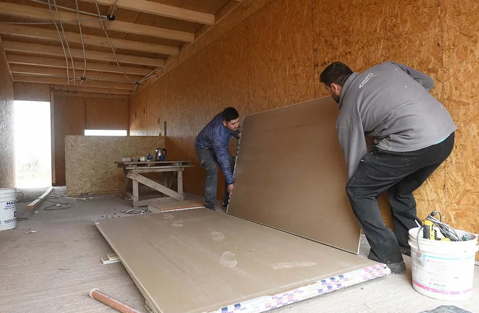 Gastón y Facundo trabajan en la colocación de placas en el interior de una vivienda.
Foto: José Gutierrez / Los Andes