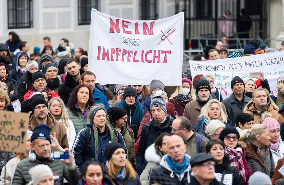 "No a la vacunación obligatoria", dice el cartel que sostiene un manifestante austríaco durante una protesta contra antivacunación en Ballhausplatz en Viena, Austria. (Gentileza CNN)