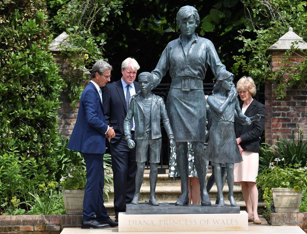 El escultor Ian Rank-Broadley, Charles Spencer y Lady Sarah McCorquodale miran la estatua de la princesa Diana, después de su inauguración. 